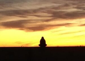 Die Person die auf der Mauer sitzt symbolisieren die Grenzen des Menschseins.