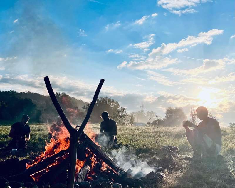 Maenner am Lagerfeuer