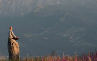 Alleine auf einem Stein in einer Yogahaltung stabil und meditativ zeigt für mich die Essenz der Yoga-Bedeutung